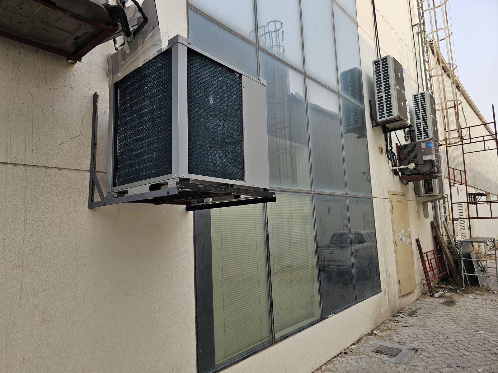 Condenser unit exterior wall mount